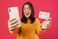 Image of delighted caucasian girl showing cellphone and credit card