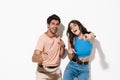 Image of delighted couple smiling and pointing fingers upward