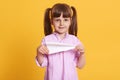 Image of delighted positive girl standing isolated over yellow background, holding paper plane in both hands, having fun, playing Royalty Free Stock Photo