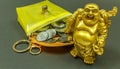 IMAGE DEPICTING THE FINANCIAL SITUATION SEEN WITH COINS INSIDE A PURSE WITH LAUGHING BUDDHA. WITH SELECTIVE FOCUS ON THE SUBJECT. Royalty Free Stock Photo