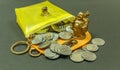 IMAGE DEPICTING THE FINANCIAL SITUATION SEEN WITH COINS INSIDE A PURSE WITH LAUGHING BUDDHA. WITH SELECTIVE FOCUS ON THE SUBJECT. Royalty Free Stock Photo