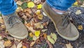 Image depicting two shoes of a man walking on autumn leaves.