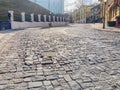 Image depicts a cobblestone street with herringbone pattern, overcast sky, and diagonal crack The scene is set in an old Royalty Free Stock Photo