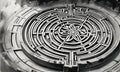 black and white complex, intricate maze with central flower-like design, surrounded by concentric circles and