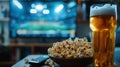 Home viewing of football match with beer, popcorn and remote control on table in front of modern TV and American football stadium
