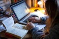 Student writing notes in a cozy home workspace at night Royalty Free Stock Photo