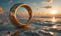 golden ring rests on sandy beach, with serene sunset and calm ocean in the background. Royalty Free Stock Photo