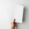 A hand holding a stack of blank white paper sheets Royalty Free Stock Photo