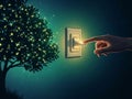 Hand activating glowing switch near illuminated tree Royalty Free Stock Photo