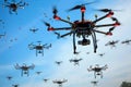 A Swarm of Drones Flying in Formation Across a Blue Sky Royalty Free Stock Photo