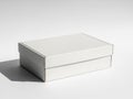 Minimalist white cardboard box on plain surface Royalty Free Stock Photo