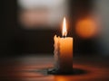 A single candle flame flickering softly in a dimly lit ambiance Royalty Free Stock Photo