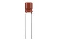 Red cylindrical capacitor with two protruding metal leads for electronic circuits Royalty Free Stock Photo