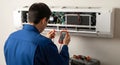 air conditioning repair: technician diagnosing a split system with a multimeter, showcasing maintenance and technical expertise in Royalty Free Stock Photo