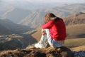 Image of a depressed and upset young woman sitting on the edge of an abyss