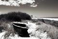 image of a deserted beach with an old boat broken fence around the dunes and clusters of sea oats.