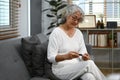 Image of diabetic middle age woman checking blood glucose levels with a glucose meter. Diabetes and health care concept