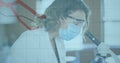 Image of digital interface showing statistics with scientist using microscope wearing face masks
