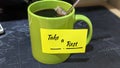 A lime green ceramic coffee mug featuring a yellow reminder note. Royalty Free Stock Photo