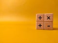 The image displays four wooden blocks with basic mathematical operation symbols on a yellow background Royalty Free Stock Photo