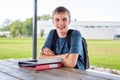 Happy teenager studying outdoors at a picnic table. Royalty Free Stock Photo