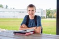 Happy teenager studying outdoors at a picnic table. Royalty Free Stock Photo