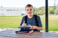 Happy teenager studying outdoors at a picnic table. Royalty Free Stock Photo