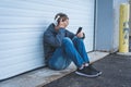 Sad teenager wearing headphones and listening to music. Royalty Free Stock Photo