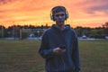 Lonely teenager listening to music at sunset.