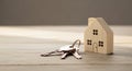keys and wooden house model on a wooden surface Royalty Free Stock Photo