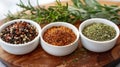 Three white ceramic bowls of dried herbs and spices on a wooden table Royalty Free Stock Photo