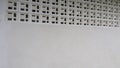 The image displays a white concrete wall featuring decorative ventilation blocks on the upper section. These Royalty Free Stock Photo