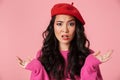 Image of displeased beautiful asian girl wearing beret throwing up arms