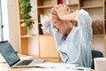 Image of displeased woman grabbing her head while working with laptop