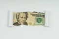 An image of a 20 dollar bill is visible in the torn hole of a sheet of paper Royalty Free Stock Photo