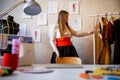 Image of dressmaker woman standing next to dress patterns