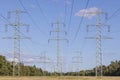 Image of an electricity pylon from the ground perspective in front of a blue sky with white clouds Royalty Free Stock Photo