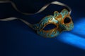 Image of elegant blue and gold venetian, mardi gras mask over dark background. Royalty Free Stock Photo