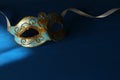 Image of elegant blue and gold venetian, mardi gras mask over dark background. Royalty Free Stock Photo