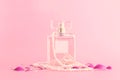 Image of elegant perfume bottle over pink pastel background