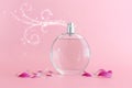 Image of elegant perfume bottle spraying over pink pastel background Royalty Free Stock Photo