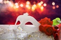 Image of elegant venetian mask and red roses over wooden table Royalty Free Stock Photo