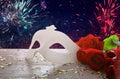 Image of elegant venetian mask and red roses over wooden table Royalty Free Stock Photo