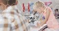 Image of elemental diagrams over smiling caucasian schoolgirl using microscope in science class Royalty Free Stock Photo