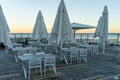 Empty chairs and tables of closed outdoor restaurant with sea view Royalty Free Stock Photo