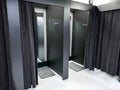 Image of empty fitting room in shopping mall with dark black curtains and mirrors