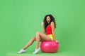 Image of energetic woman 20s wearing summer clothes lifting dumbbells while sitting on fitness ball during aerobics Royalty Free Stock Photo