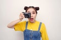 Image of excited paparazzi girl  holding retro camera at face and photographing isolated over white background Royalty Free Stock Photo