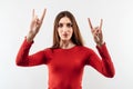 Image of excited woman laughing and making horn gesture with fingers Royalty Free Stock Photo