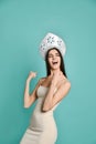 Image of excited young woman in kokoshnik hat standing isolated over blue background make winner gesture. Royalty Free Stock Photo